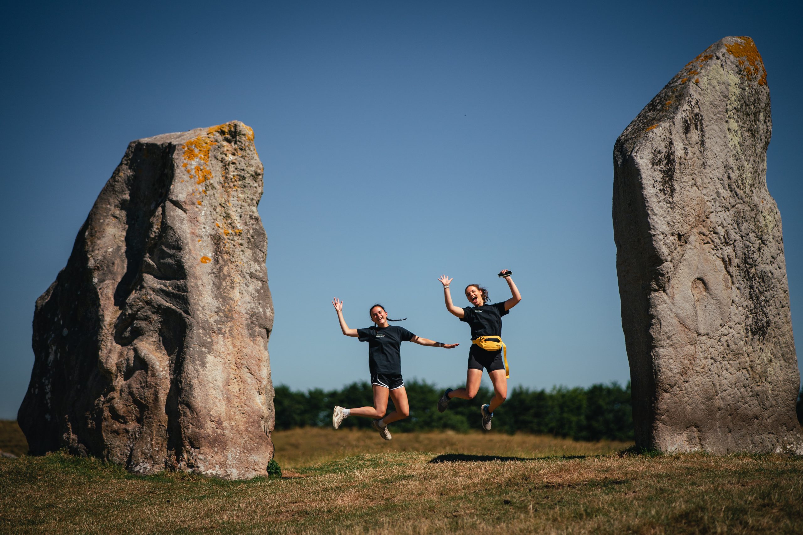 Race to the Stone image. Two women jumping in between the stones